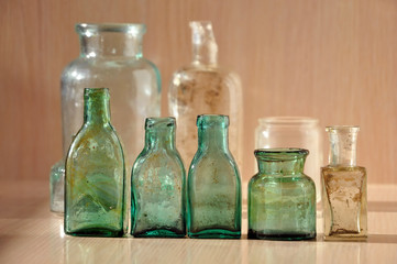 Small different green glass vintage bottle closeup.