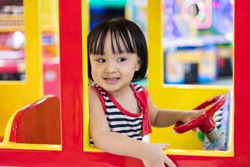 Fototapeta na wymiar Happy Asian Chinese Little Girl Driving Toy Bus