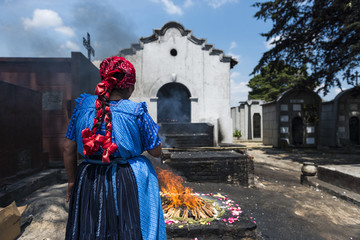 Naklejka premium Maya woman performing a traditional mayan ritual in the cemetery of the town of Chichicastenango, in Guatemala