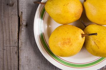 Fresh ripe organic yello pears on rustic wooden table, natural background, diet food.