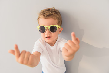 Little boy in sunglasses posing in studio