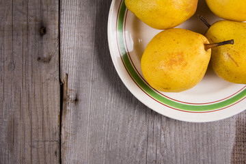 Fresh ripe organic yello pears on rustic wooden table, natural background, diet food.