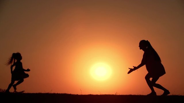 The Little Girl Runs To Hug Mom,the Sunset Slow Motion Silhouette