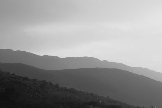 Black and white landscape with mountains, sky and fog