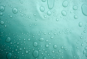 Drops of water on a dusty green color background. Shallow depth of field. Selective focus. Toned.