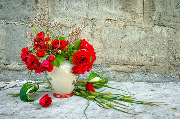 bouquet of red roses in vase near the concrete wall with copy space for your text