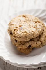 Homemade chocolate chip oatmeal cookies stacked on two white antique plates