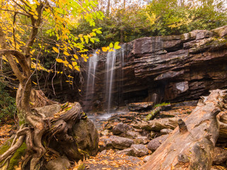 Waterfall over rocks with tree in foreground