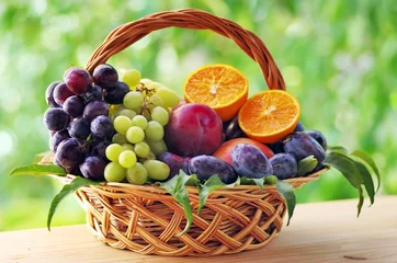 Fototapeten wooden basket full of fruits on table © inacio pires