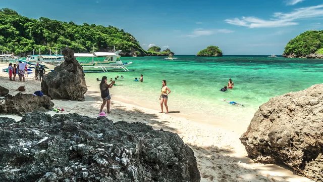 People relax on the azure beach of Boracay Island. 4K TimeLapse - August 2016, Boracay, Philippines
