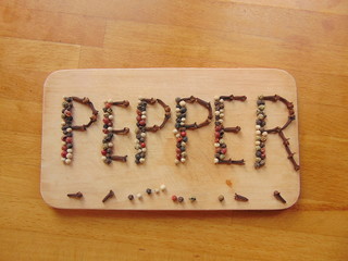 Obraz na płótnie Canvas Pepper written on cutting board with pepper 