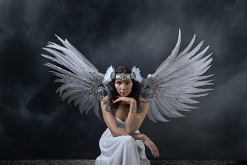 Beautiful woman in white dress with angel wings