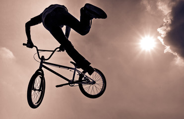 Fototapeta na wymiar Bmx rider. BMX cyclyst. Sport man whit bike. silhouette of a cyclist with sunlight background. Silhouette of a man doing an extreme jump with a mountain bike. BMX rider making a bike jump.