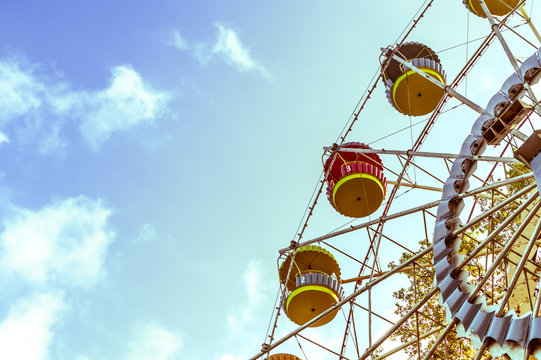 Vintage ferris wheel on the blue sky with clouds