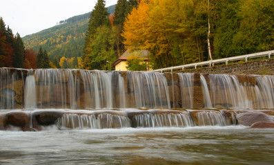 small waterfall of mountain river in autumn