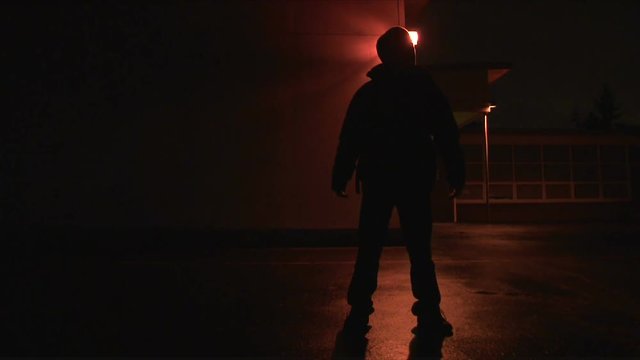 Person disappears and reappears exterior, night, then walks towards camera blacking out lens.
