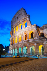 Fototapeta premium view of Colosseum facade close up illuminated at night in Rome, Italy, vertical shot