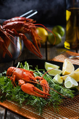 Boiled crayfish with fresh greens and a citrus on  black plate in style  rustic