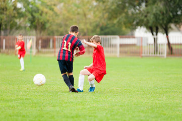 Fototapeta premium Two young soccer football players fighting for the ball