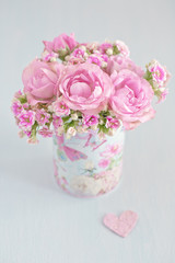Lovely bunch of flowers in a vase ,decorated with a  heart on a table .