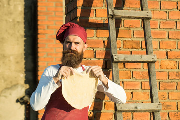 Man cook holding dough