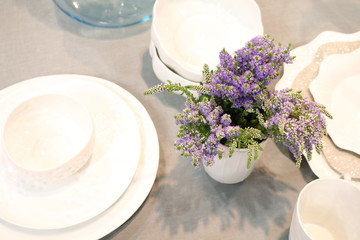 decorated table with white crockery and with a bouquet of flowers