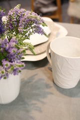 decorated table with white crockery and with a bouquet of flowers