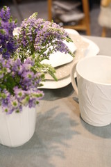 decorated table with white crockery and with a bouquet of flowers
