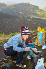 Fototapeta na wymiar woman hiker cooking outdoor in camping, Iceland