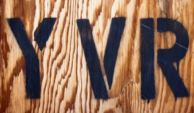 Black YVR stamp on old wooden cargo box