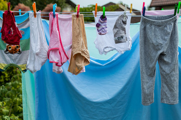 Baby laundry hanging on a clothesline in garden