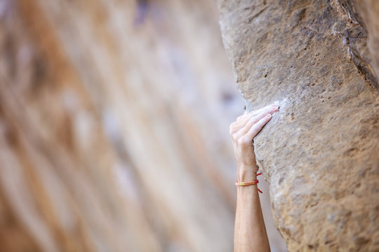 Close up climber's hand on ledge on cliff 