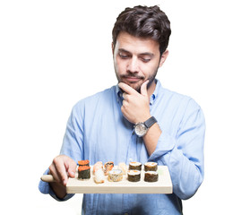 Young man eating sushi on white background