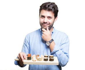 Young man eating sushi on white background