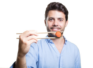 Young man eating sushi on white background