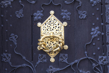 close up of a black traditional German doorway with golden doorknob accents