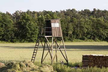 Wooden watch tower on the green farm field in Germany