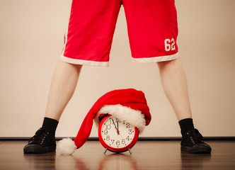 Closeup of man with alarm clock. Christmas time.