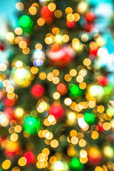 Fototapeta na wymiar Background of christmas tree with bokeh lights and defocused xmas balls.