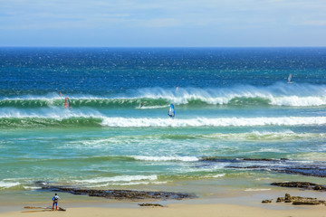 Fototapeta na wymiar Scarborough Beach. Windsurf in Cape Town, South Africa. Surfer tries to take a high and powerful wave. Atlantic coast, Cape Peninsula.
