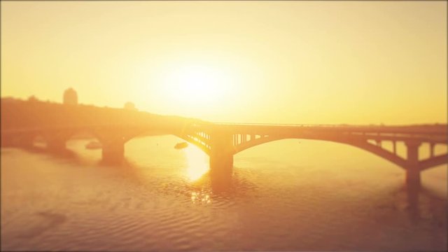 Aerial Drone Flight Footage: Metro Bridge through the Dnipro river in sunset soft light. Video blurred and processed in orange glow. Magestic landscape. Kiev, Ukraine, Europe. 4K resolution.