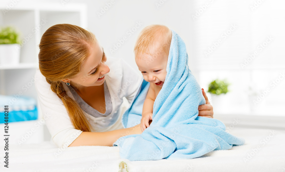 Poster happy family mother and baby in a blue towel after bathing