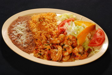 Hot spicy mexican shrimps with rice and beans and salad