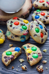 Shortbread cookies with multi-colored candy and chocolate chips on wooden table, vertical