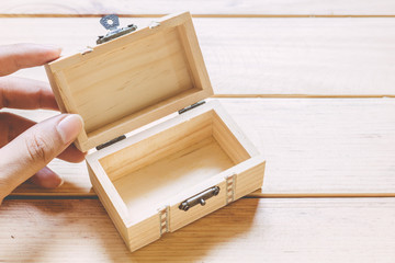 Hands hold a empty(blank) opened wooden box on wooden table
