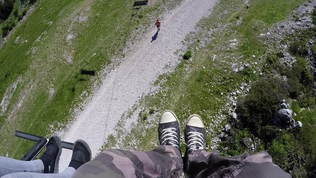 Sitting in chairlift cable hoist on bright summer day, climbing to Vogel mountain in Slovenian national park Triglav