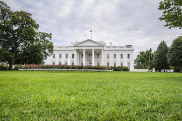 Fototapeta na wymiar The White House in Washington D.C. at a cloudy day, green lawn in foreground, Executive Office of the President of the United States, USA