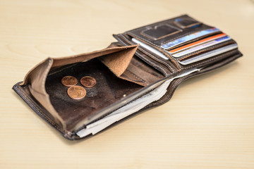 leather wallet with three Euro cent coins inside on wooden table