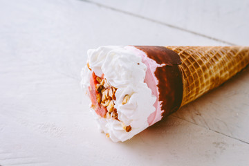 Ice cream strawberry in waffle cone on  wooden background