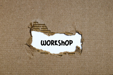 The word workshop appearing behind torn paper